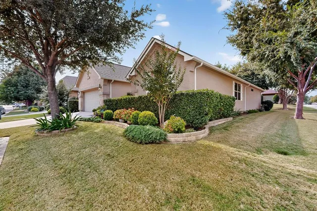 a view of a house with a yard and large tree