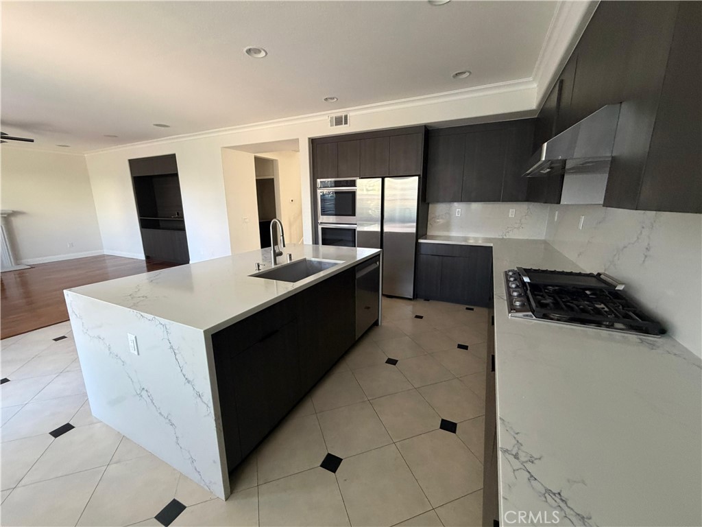 11516 Venezia Way Porter Ranch, CA 91326 - Photo 13 of 35 a kitchen with a sink a stove top oven and white cabinets
