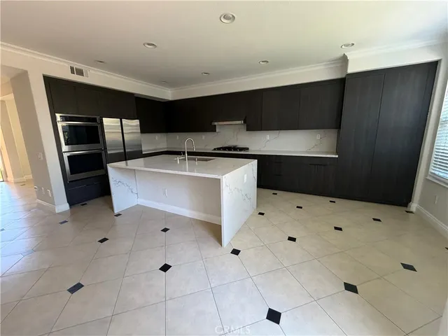 a kitchen with stainless steel appliances a stove a sink and a refrigerator
