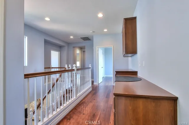 a view of a hallway with wooden floor and staircase