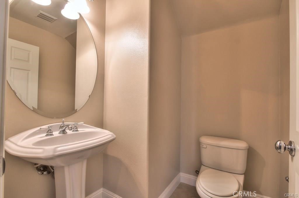 11516 Venezia Way Porter Ranch, CA 91326 - Photo 25 of 35 a bathroom with a toilet a sink and mirror