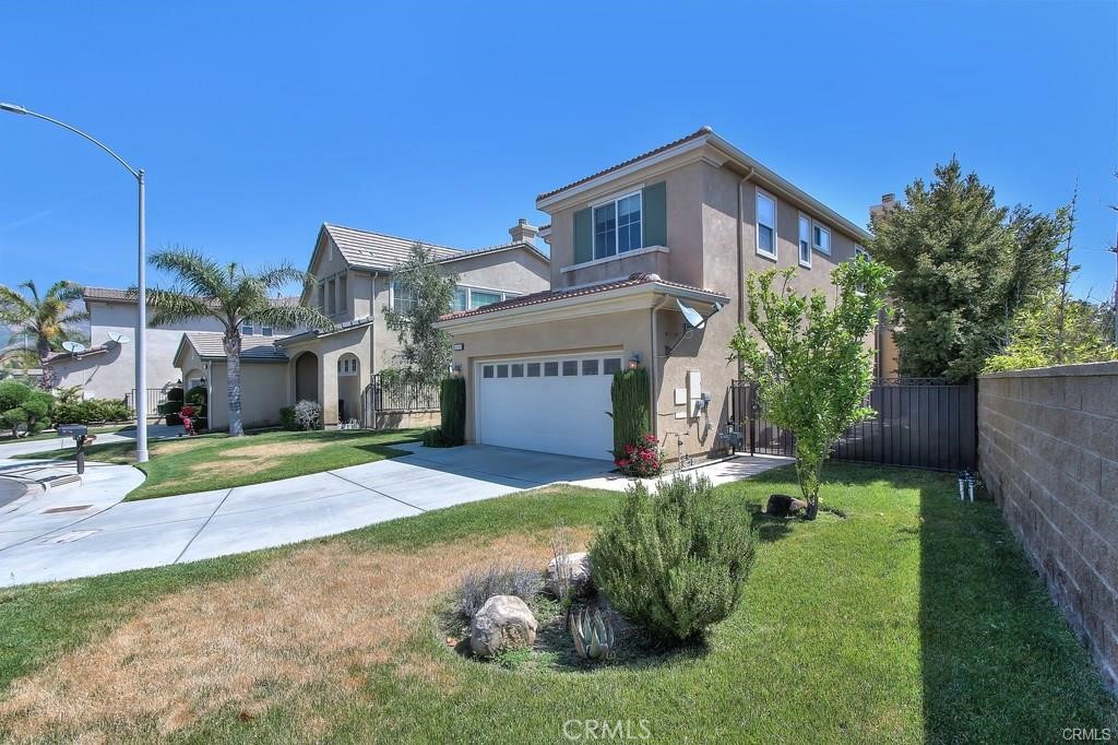 11516 Venezia Way Porter Ranch, CA 91326 - Photo 6 of 35 a front view of a house with a yard and garage