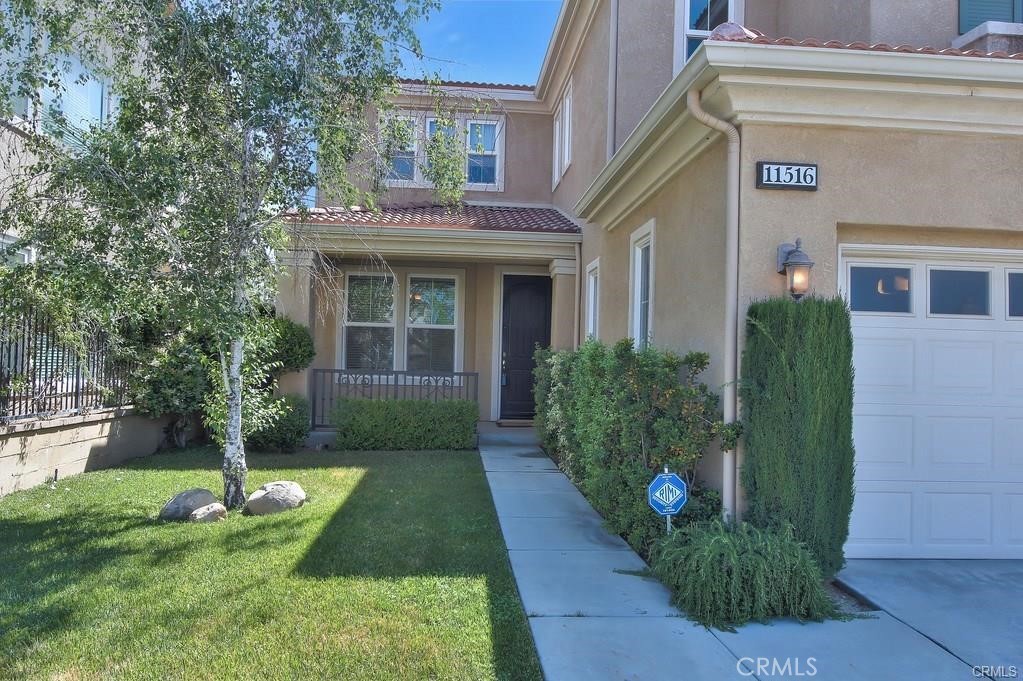 11516 Venezia Way Porter Ranch, CA 91326 - Photo 7 of 35 a front view of a house with garden