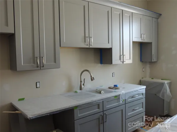 a kitchen with stainless steel appliances granite countertop a sink a stove and cabinets