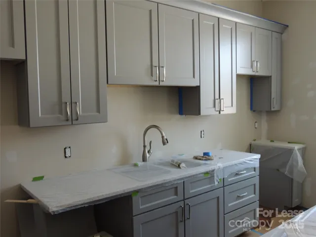 a kitchen with stainless steel appliances granite countertop a sink a stove and cabinets