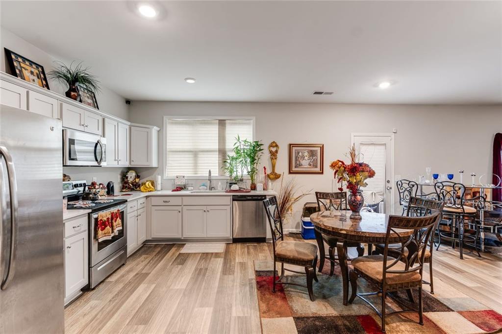 227 Waters Edge Parkway Temple, GA 30179 - Photo 20 of 26 a kitchen with stainless steel appliances granite countertop a dining table chairs stove refrigerator and cabinets