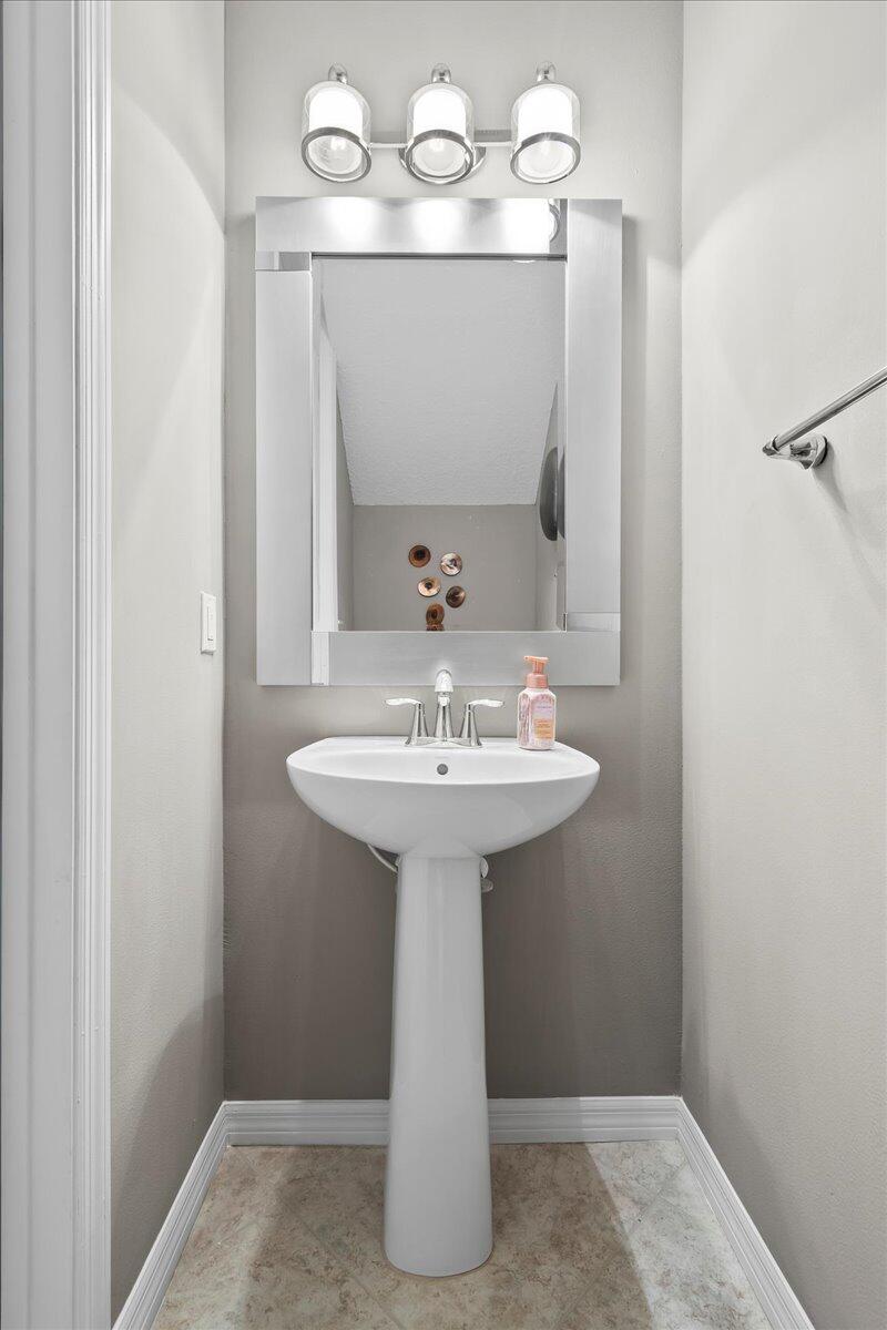692 Southwest Glen Crest Way Stuart, FL 34997 - Photo 12 of 37 a bathroom with a sink a mirror and vanity