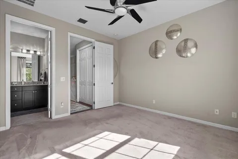 an empty room with fan and windows