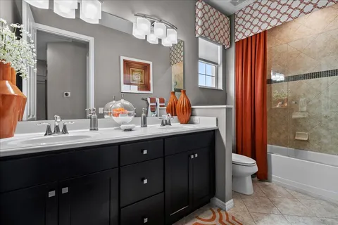 a bathroom with a double vanity sink toilet and shower