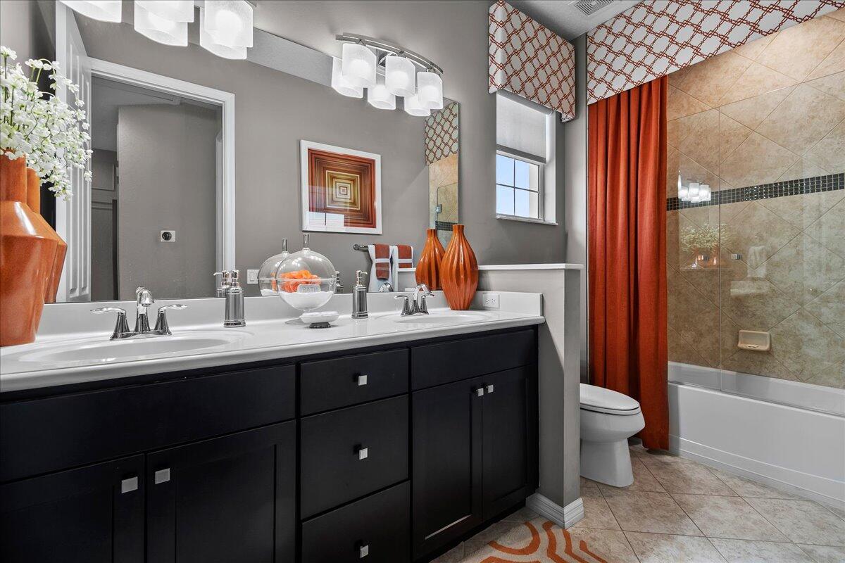 692 Southwest Glen Crest Way Stuart, FL 34997 - Photo 19 of 37 a bathroom with a double vanity sink toilet and shower