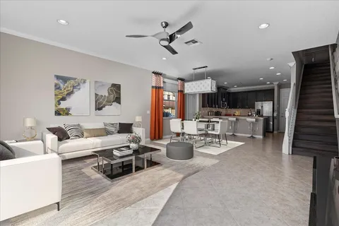 a living room with furniture kitchen view and a chandelier