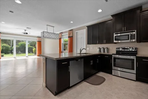 a kitchen with stainless steel appliances granite countertop a stove a sink and a microwave