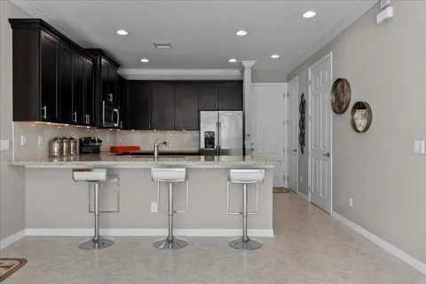 a kitchen with white cabinets and sink