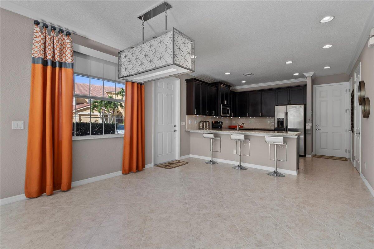 692 Southwest Glen Crest Way Stuart, FL 34997 - Photo 9 of 37 a view of kitchen with stainless steel appliances granite countertop a refrigerator and a stove top oven