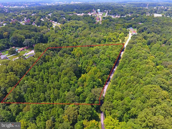 an aerial view of residential houses with outdoor space and trees