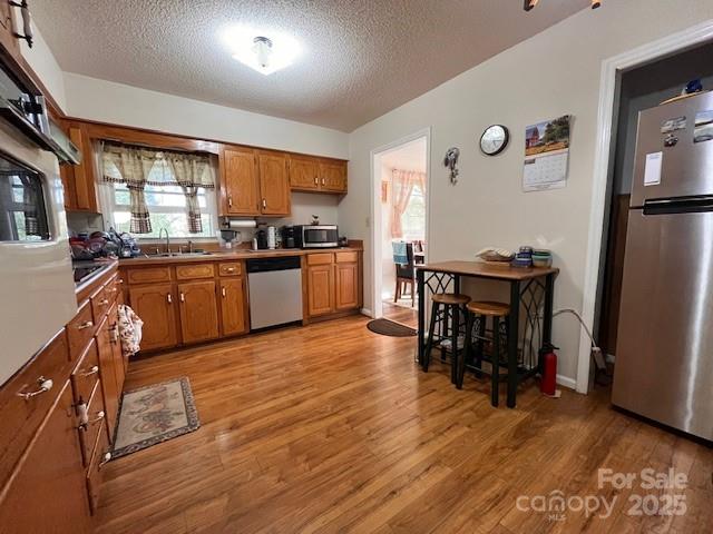 90 Long Street Marion, NC 28752 - Photo 11 of 34 a kitchen with stainless steel appliances granite countertop a refrigerator a stove top oven a sink dishwasher and dining table with wooden floor