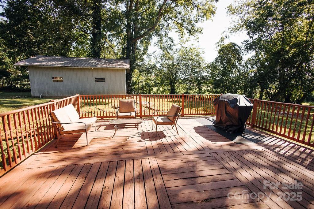 90 Long Street Marion, NC 28752 - Photo 2 of 34 a view of a roof deck with table and chairs couches with wooden floor and fence
