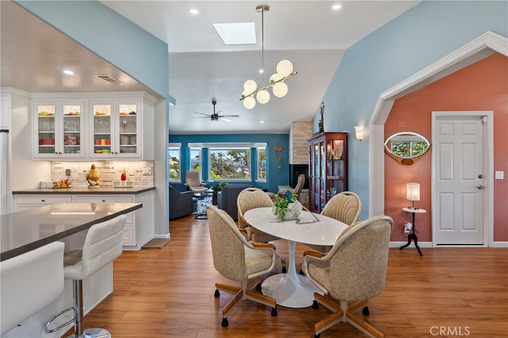 7215 San Gabriel Road Atascadero, CA 93422 - Photo 17 of 74 a dining room with wooden floor a chandelier a wooden table and chairs