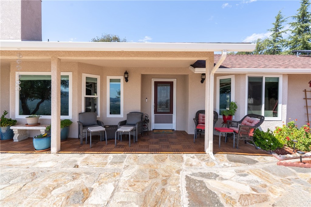 7215 San Gabriel Road Atascadero, CA 93422 - Photo 7 of 74 a view of a patio with table and chairs potted plants and floor to ceiling window