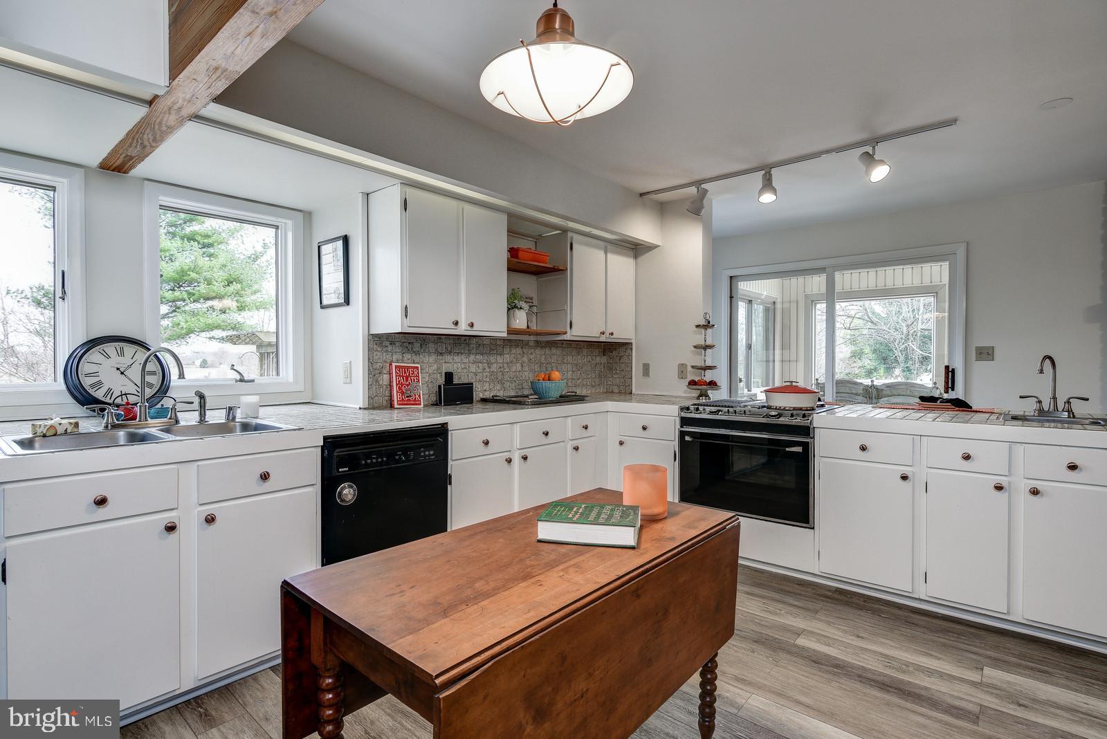 12928 Coppermine Road Union Bridge, MD 21791 - Photo 14 of 38 a kitchen with a stove a sink a dining table and chairs