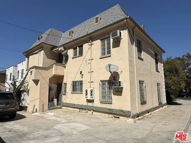 a front view of a house with white fence