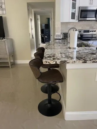a kitchen with stainless steel appliances granite countertop a sink a stove and a wooden floors