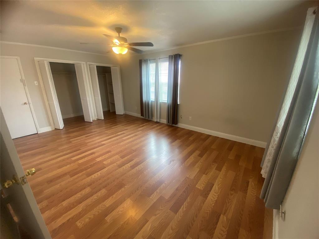 2133 Pleasant Drive Dallas, TX 75227 - Photo 18 of 40 Unfurnished bedroom with multiple closets, ornamental molding, light wood finished floors, and ceiling fan