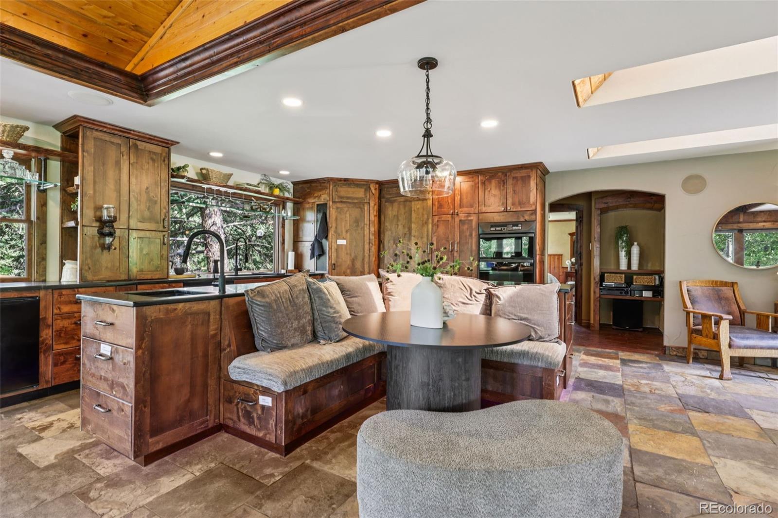 20033 Silver Ranch Road Conifer, CO 80433 - Photo 11 of 43 a living room with couches and kitchen view with wooden floor