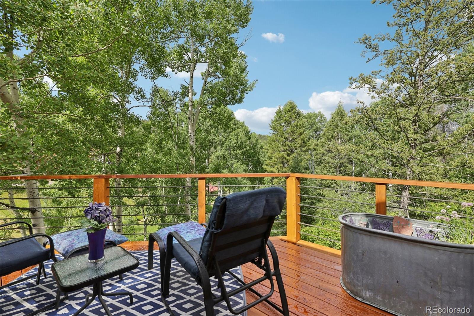 20033 Silver Ranch Road Conifer, CO 80433 - Photo 14 of 43 a view of a chairs and table in the balcony