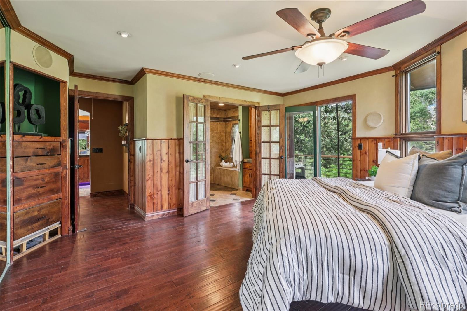 20033 Silver Ranch Road Conifer, CO 80433 - Photo 16 of 43 a bedroom with a bed and a large window with wooden floor
