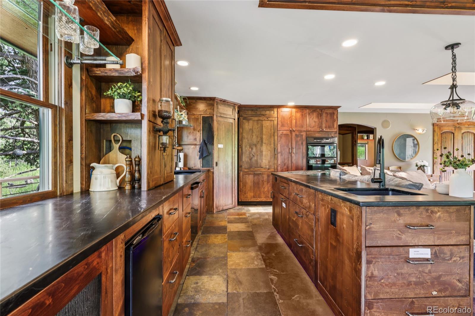 20033 Silver Ranch Road Conifer, CO 80433 - Photo 9 of 43 a kitchen with stainless steel appliances granite countertop lots of counter top space and wooden floor