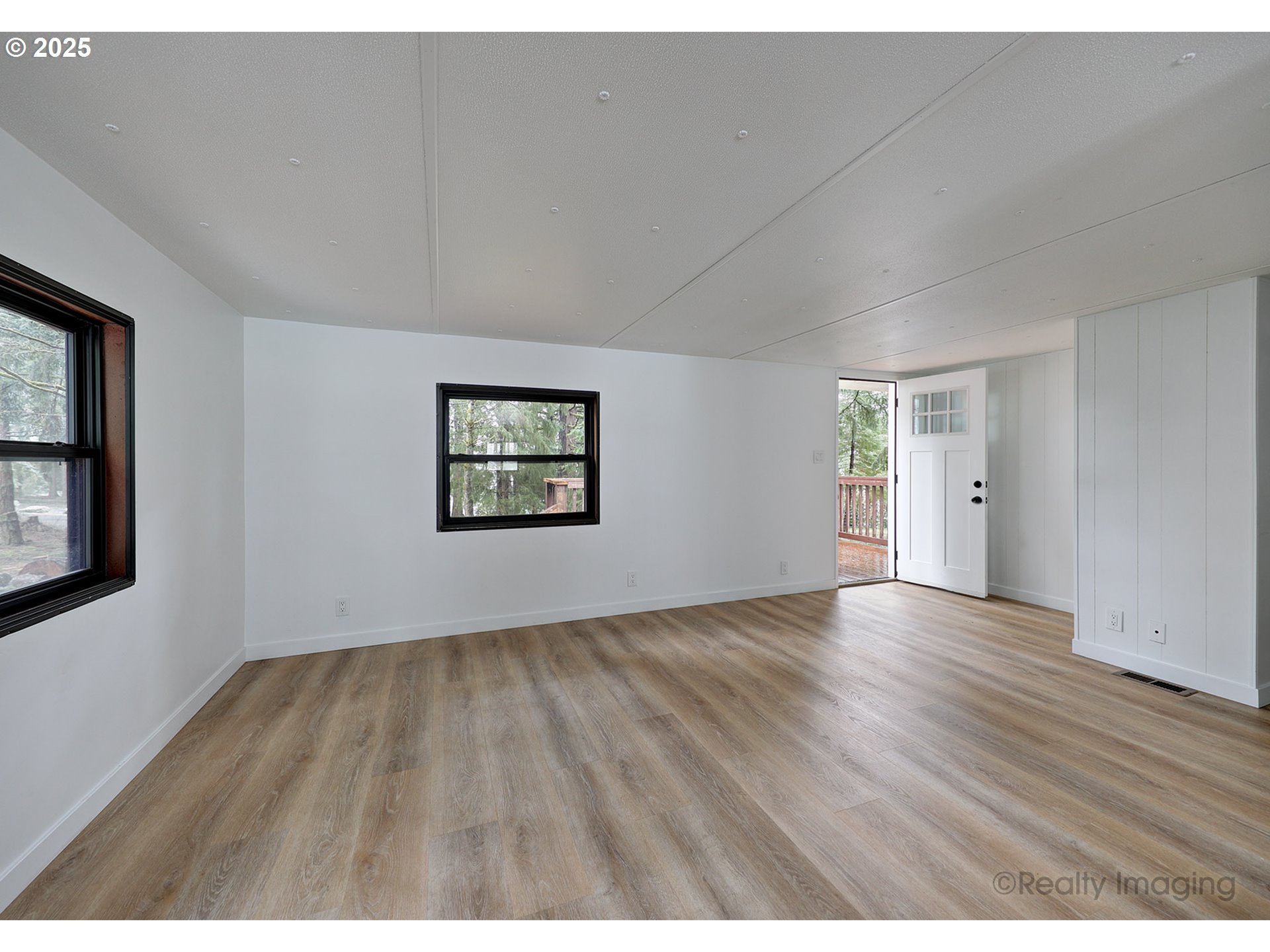 25581 South Holman Road Estacada, OR 97023 - Photo 3 of 14 an empty room with wooden floor and windows