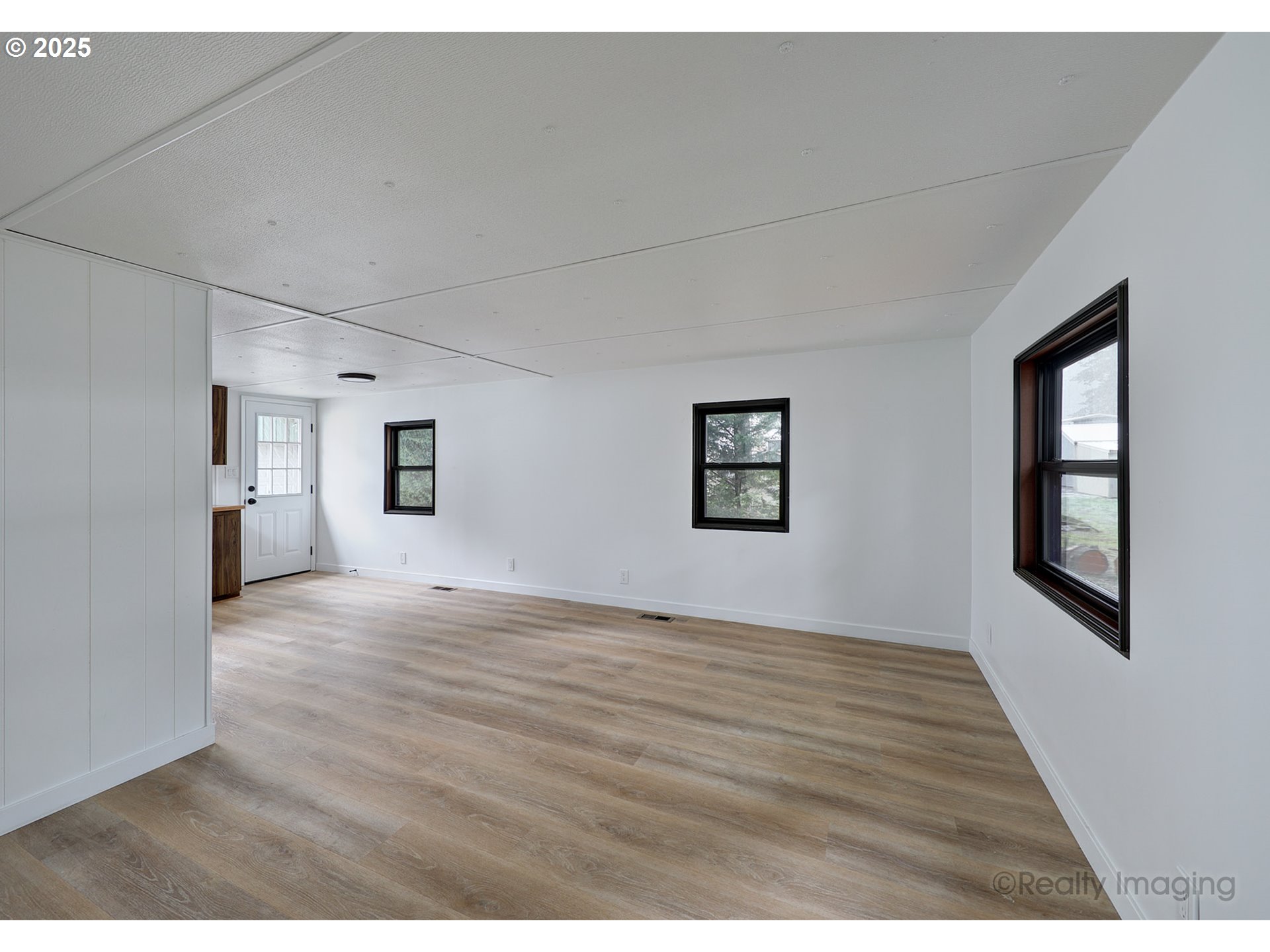 25581 South Holman Road Estacada, OR 97023 - Photo 4 of 14 a view of an empty room with a window and wooden floor