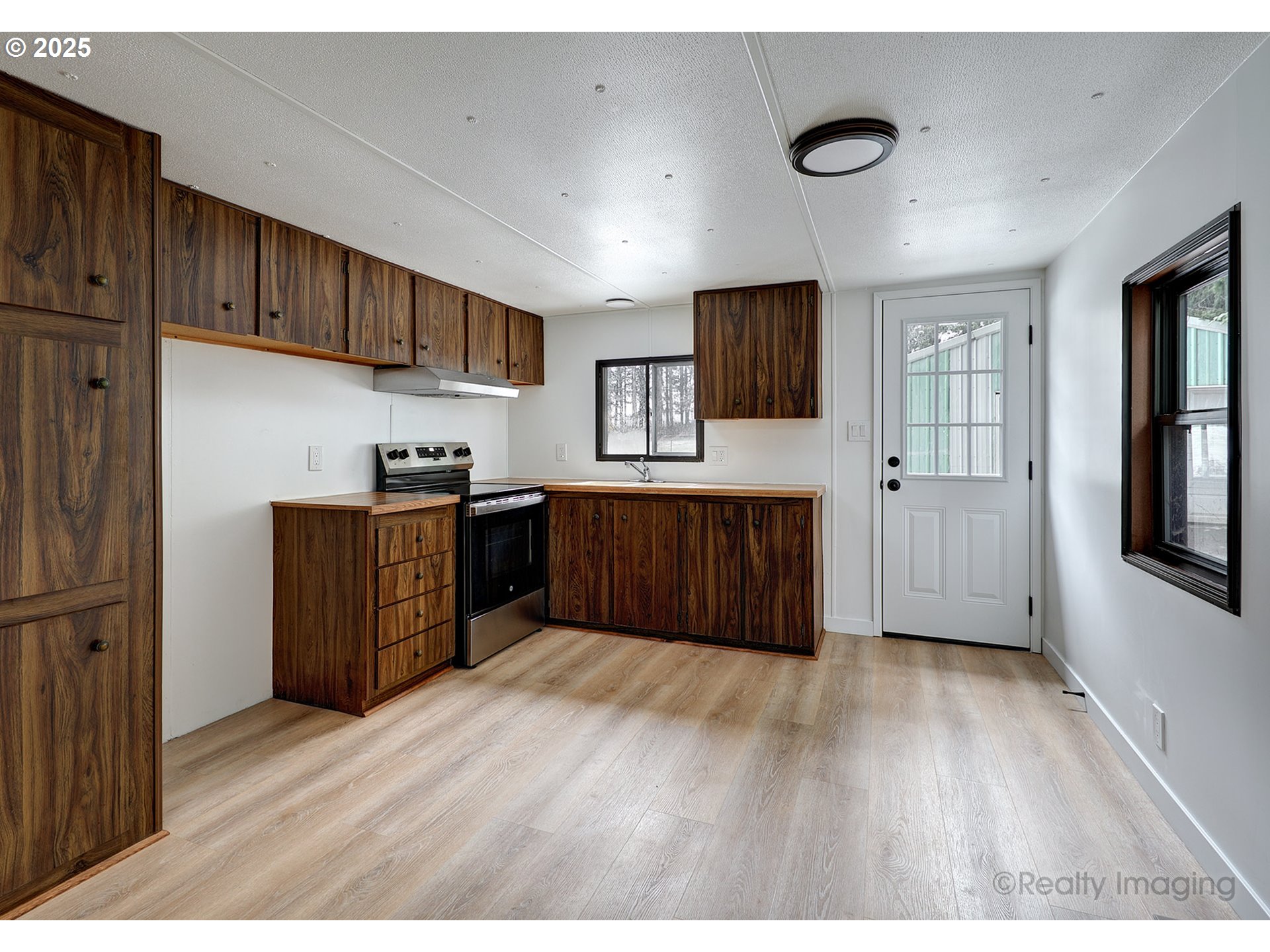 25581 South Holman Road Estacada, OR 97023 - Photo 5 of 14 a kitchen with stainless steel appliances kitchen island granite countertop a refrigerator oven a sink with wooden cabinets and wooden floor