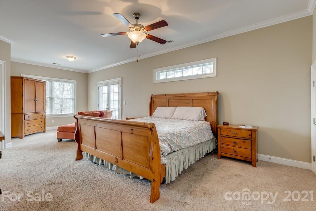 11155 Turtle Bay Court Tega Cay, SC 29708 - Photo 13 of 36 a bedroom with a bed and a chandelier