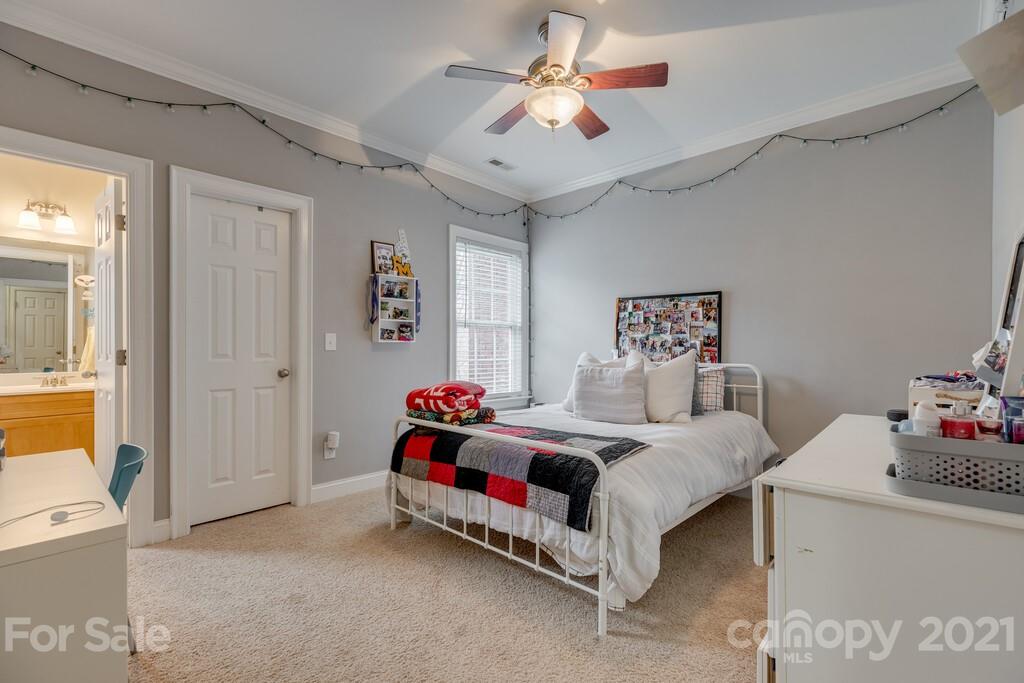 11155 Turtle Bay Court Tega Cay, SC 29708 - Photo 16 of 36 a bedroom with a bed and a chandelier