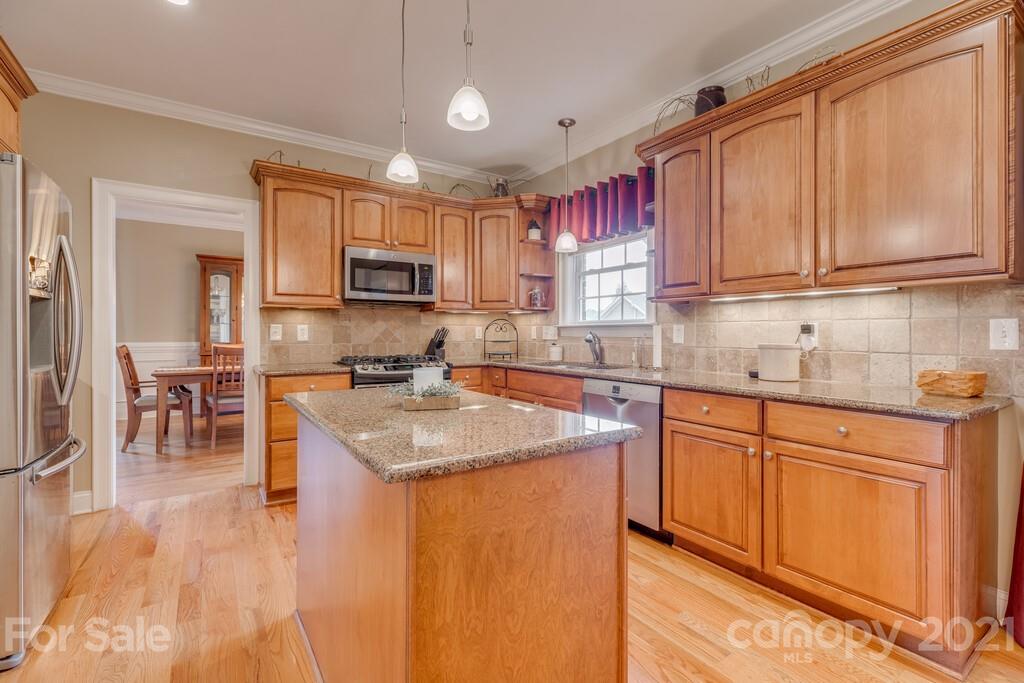 11155 Turtle Bay Court Tega Cay, SC 29708 - Photo 6 of 36 a kitchen with granite countertop a sink stainless steel appliances and cabinets