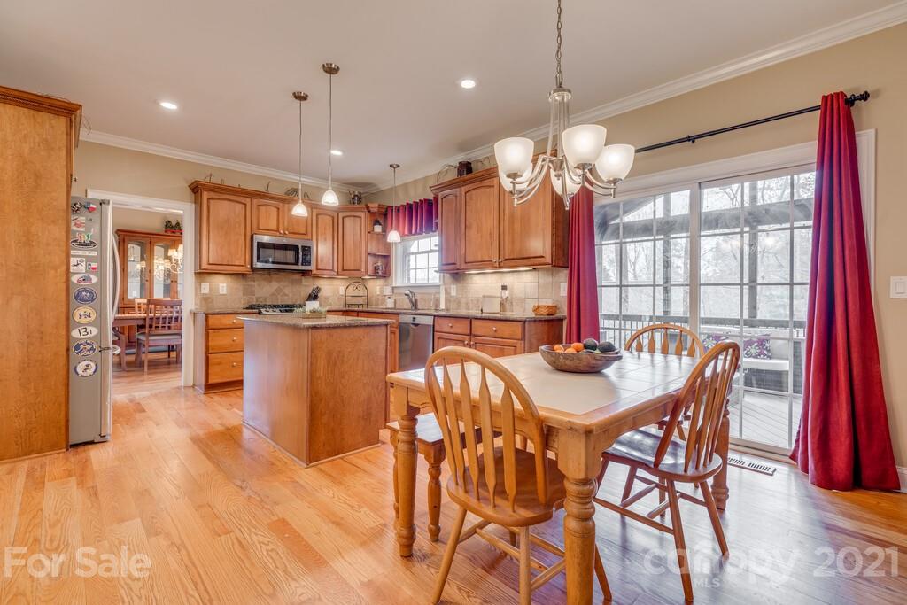 11155 Turtle Bay Court Tega Cay, SC 29708 - Photo 7 of 36 a kitchen with stainless steel appliances granite countertop a stove a refrigerator a kitchen island a table and chairs