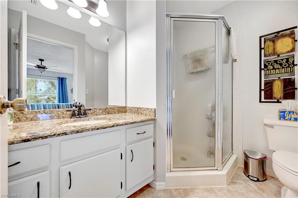 784 Landover Circle, Unit 203 Naples, FL 34104 - Photo 8 of 16 a bathroom with a granite countertop sink mirror and vanity