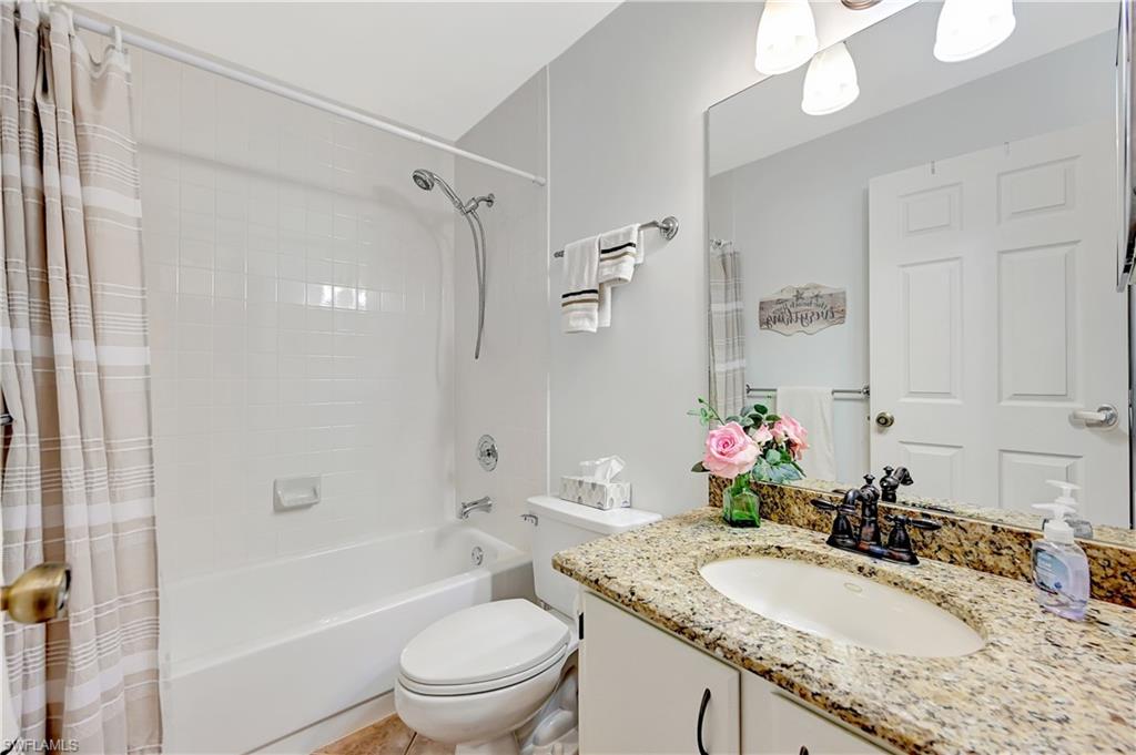 784 Landover Circle, Unit 203 Naples, FL 34104 - Photo 10 of 16 a bathroom with a granite countertop sink a toilet and shower