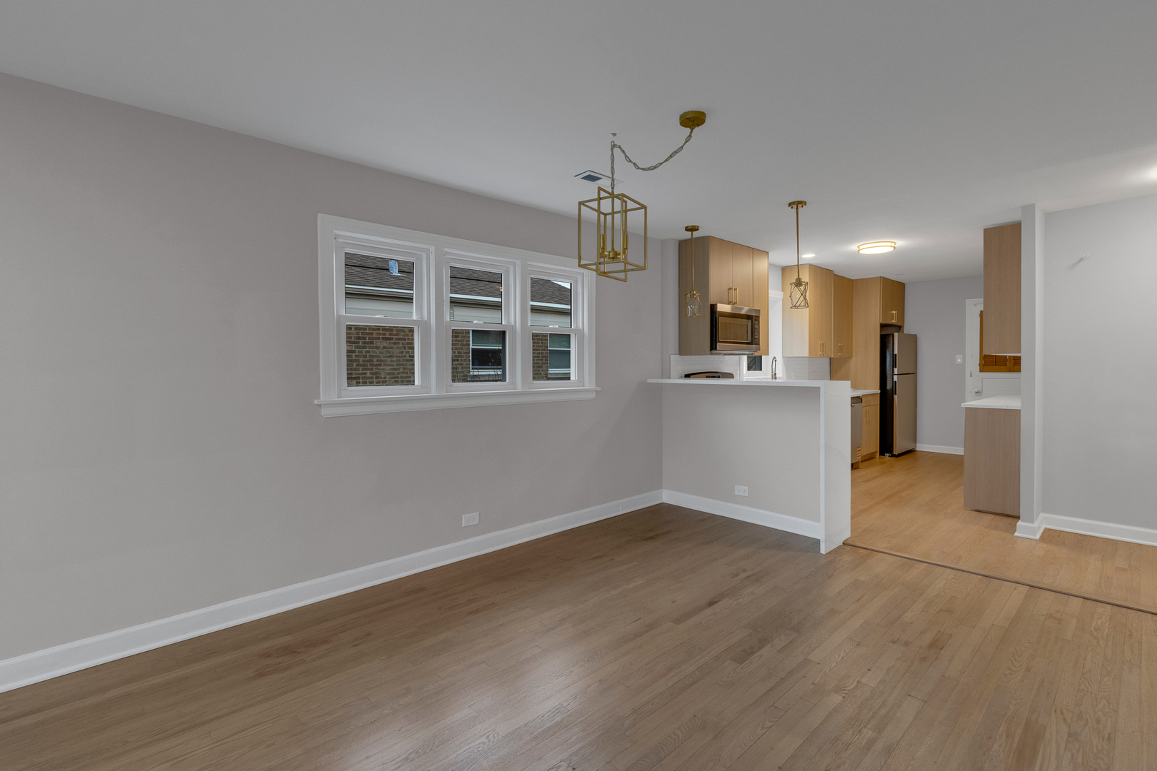 6304 North Troy Street Chicago, IL 60659 - Photo 21 of 35 a view of a kitchen with a refrigerator wooden floor and a window