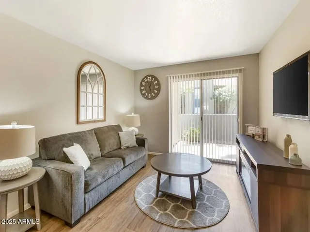 a living room with furniture a flat screen tv and a large window