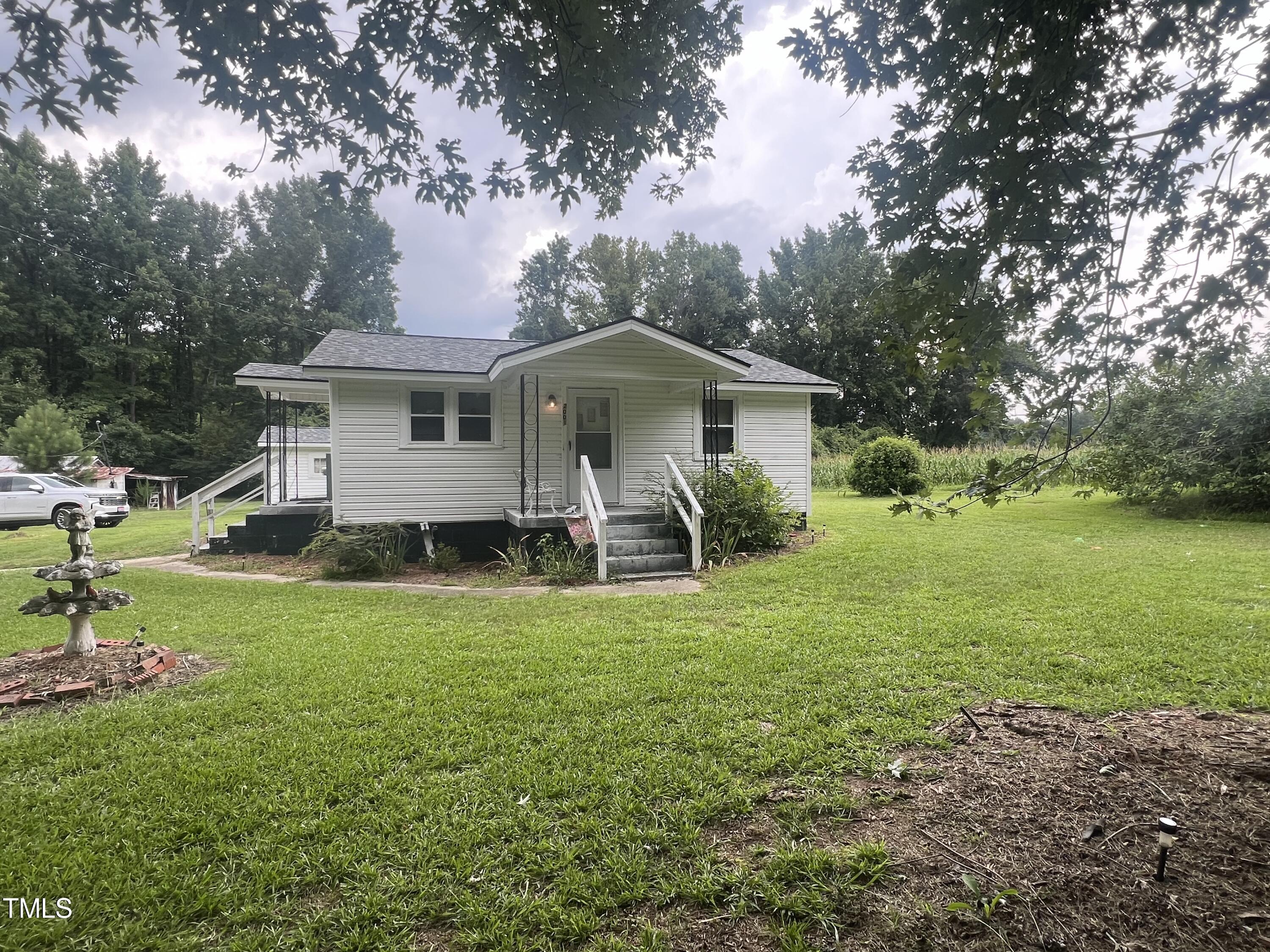 2001 Pearidge Road Angier, NC 27501 - Photo 1 of 13 a white house with a big yard and large trees