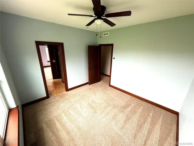 a view of a hallway with a chandelier fan