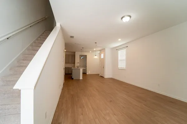 a view of a hallway with wooden floor and staircase