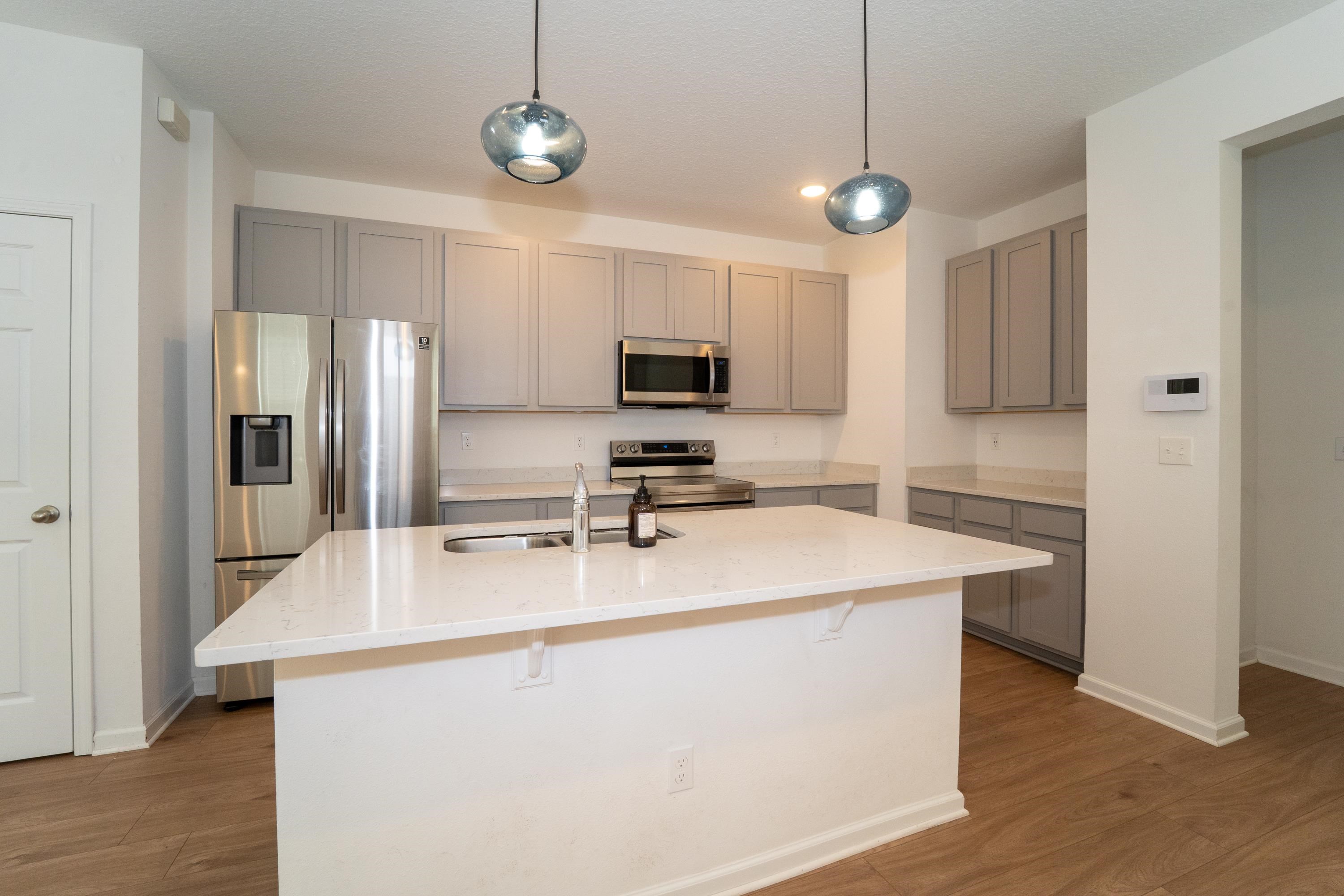 81 Ridge Lake Rd Street St. Augustine, FL 32086 - Photo 7 of 41 a kitchen with kitchen island a stove sink and refrigerator