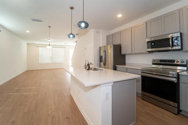 a kitchen with kitchen island a sink stainless steel appliances and cabinets