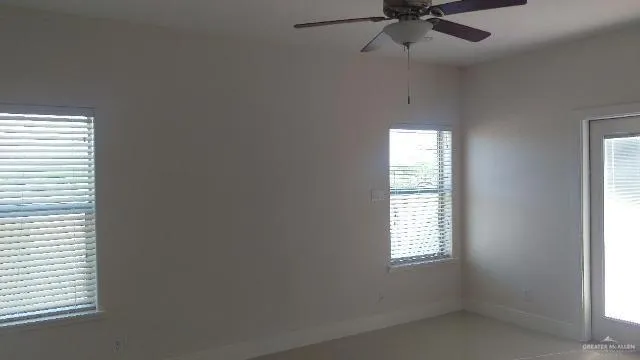 an empty room with a window and a fan