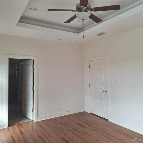 a view of an empty room with wooden floor