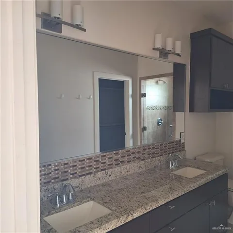 a bathroom with a granite countertop sink and a mirror